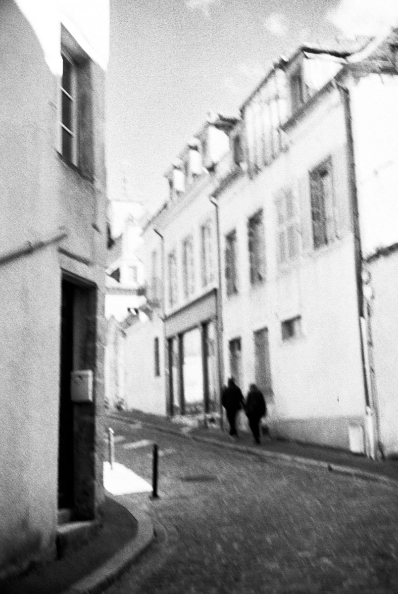 a couple walking an old cobblestone streen in Semur-en-Auxois
