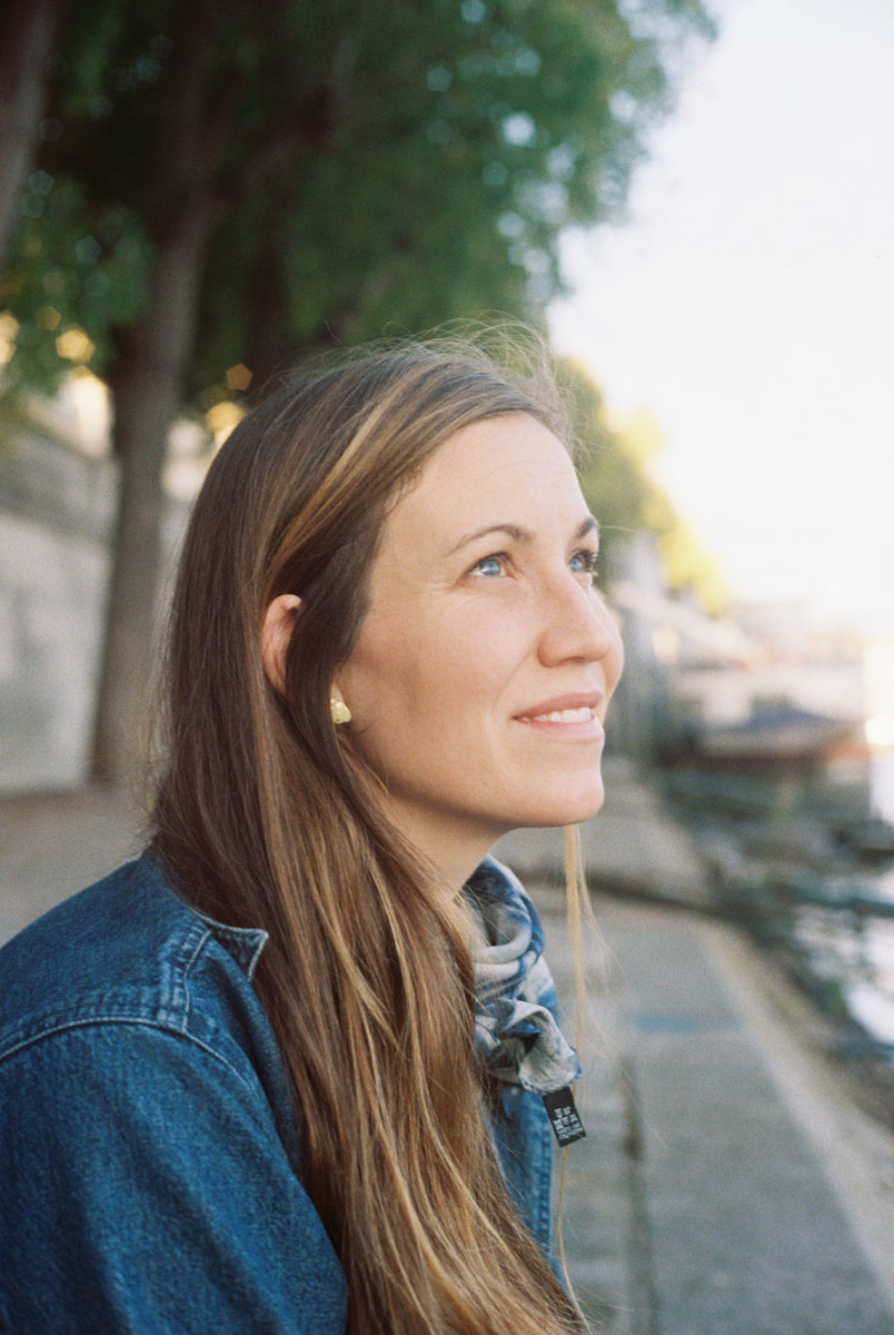 a woman sitting on the banks of the seine