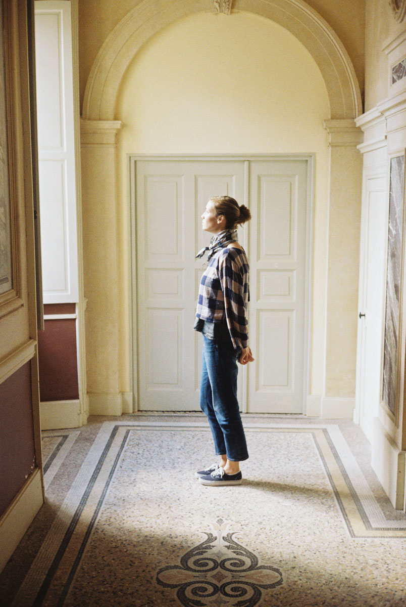 a woman looking out a window of an apartment