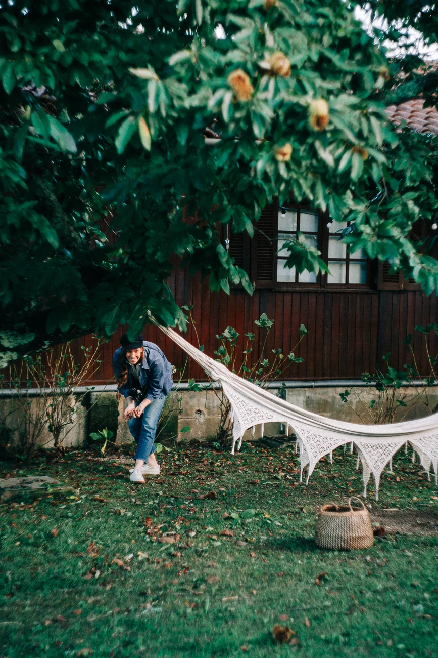 woman gathering chestnuts beneath a tree