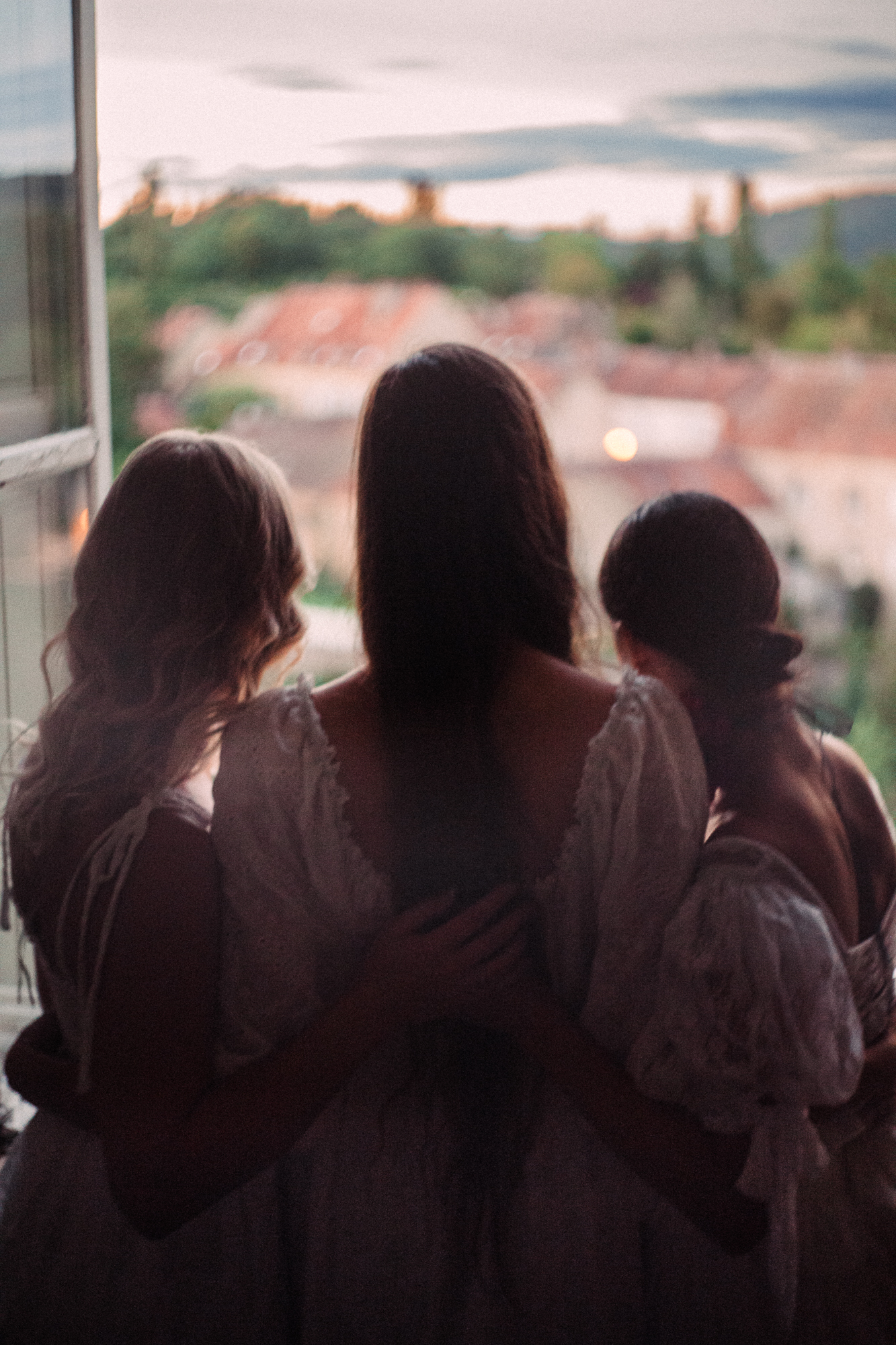 three women standing in a windowsill