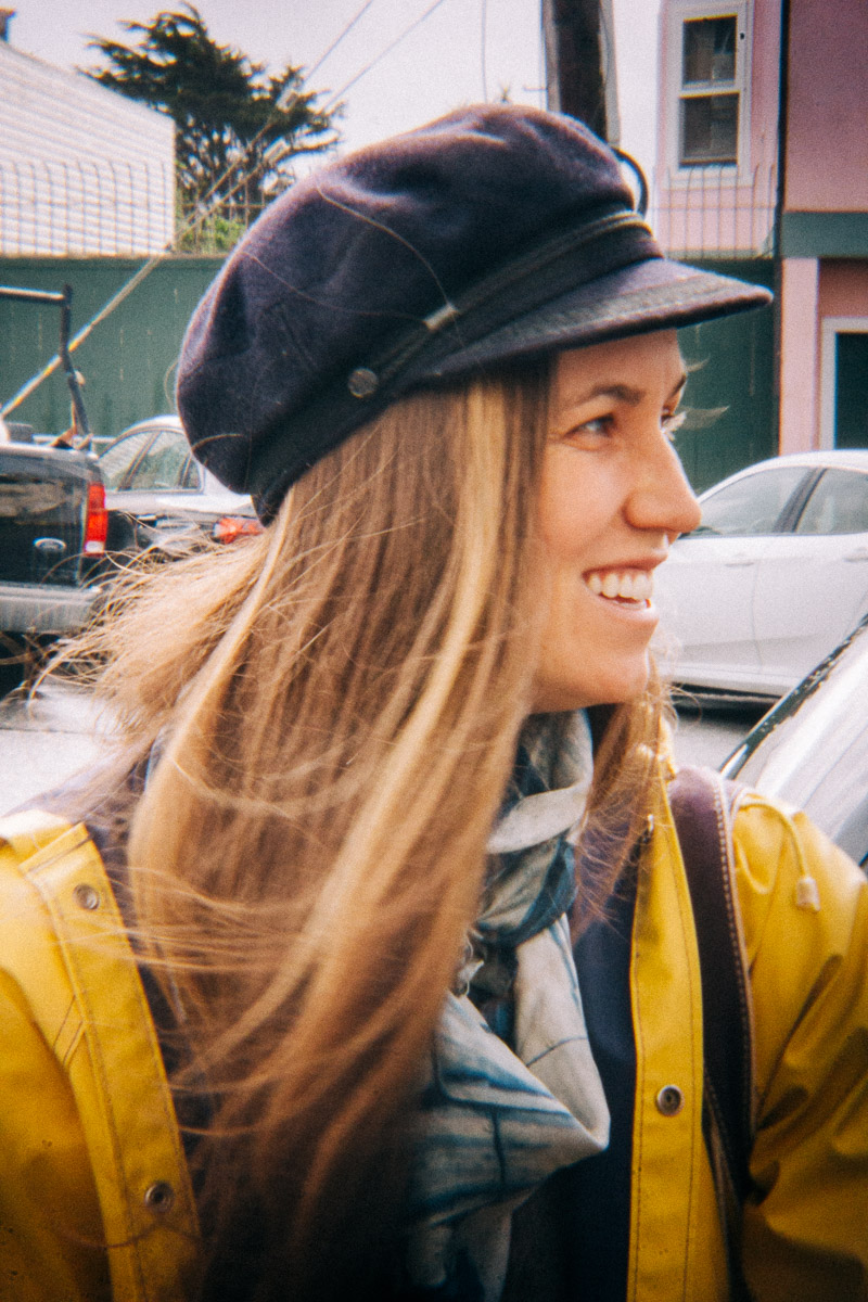 a woman in a yellow raincoat and a fisherman hat