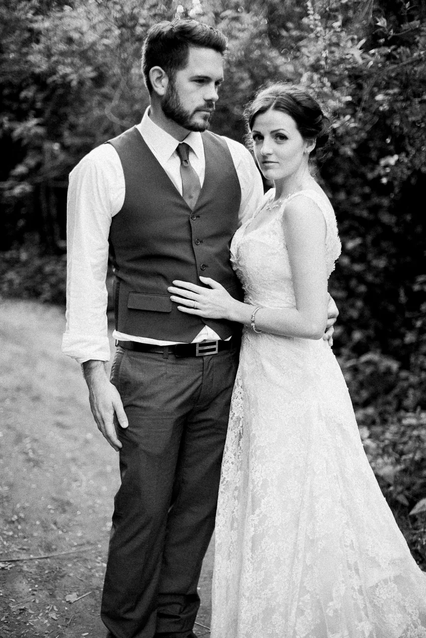 a groom and bride standing on a trail