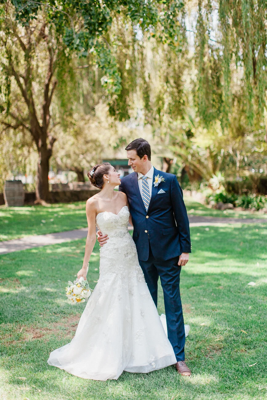 a bride and groom outside standing on a lawn