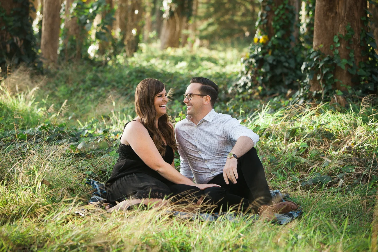 a happy couple sitting in the forest